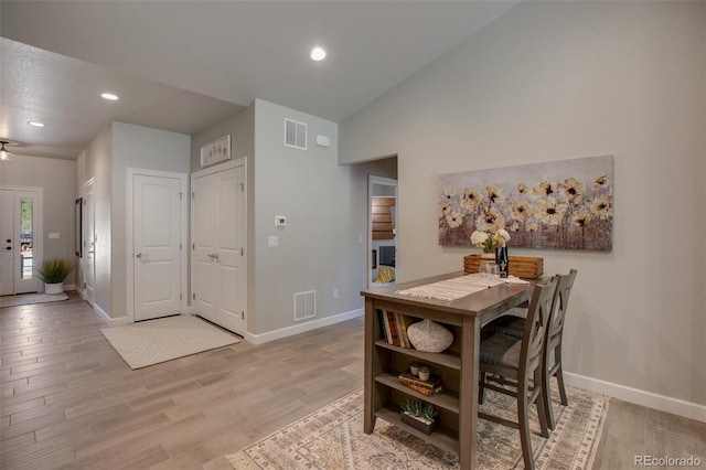 dining room with vaulted ceiling and light hardwood / wood-style flooring