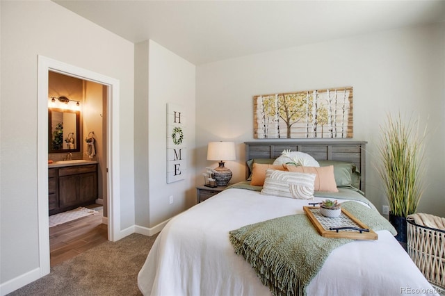 bedroom with hardwood / wood-style flooring, sink, and ensuite bathroom