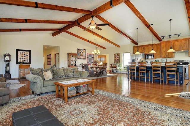 living room with beam ceiling, high vaulted ceiling, wood finished floors, and ceiling fan with notable chandelier