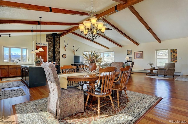 dining space with vaulted ceiling with beams, a notable chandelier, wood-type flooring, a baseboard heating unit, and baseboards