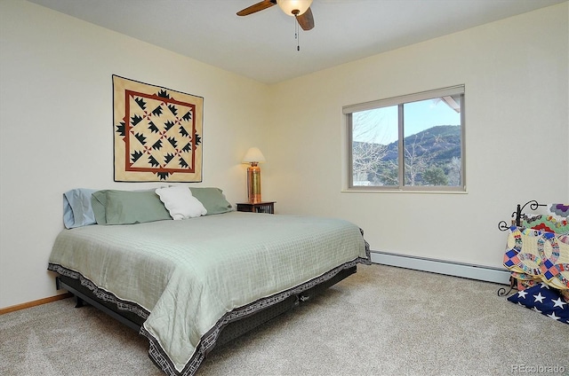 carpeted bedroom with a baseboard heating unit, baseboards, and a ceiling fan