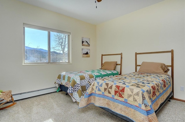 carpeted bedroom with a baseboard heating unit and ceiling fan