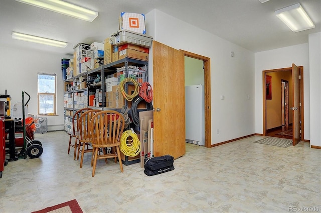 garage featuring baseboards and white refrigerator