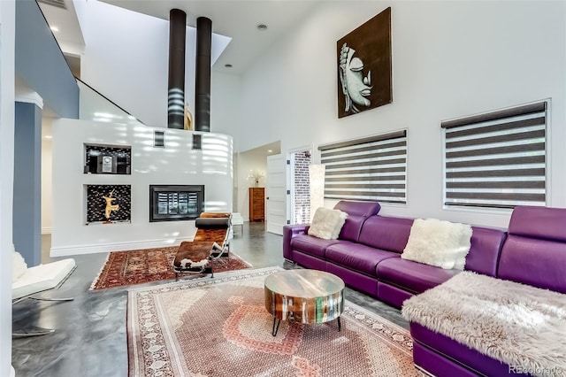 living room with a towering ceiling and concrete floors