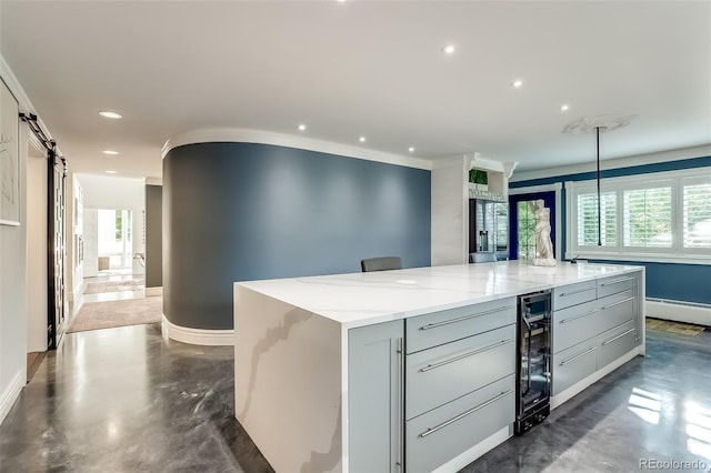 kitchen featuring a barn door, light stone countertops, gray cabinets, a spacious island, and wine cooler