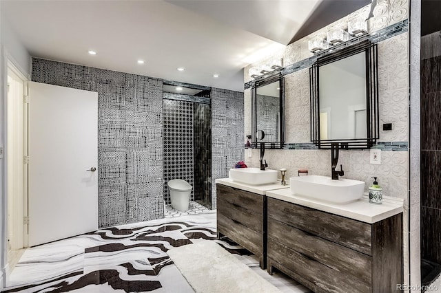 bathroom with tile walls, toilet, a tile shower, and vanity