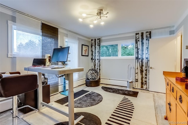 interior space with a baseboard heating unit, a chandelier, light brown cabinets, and light hardwood / wood-style floors