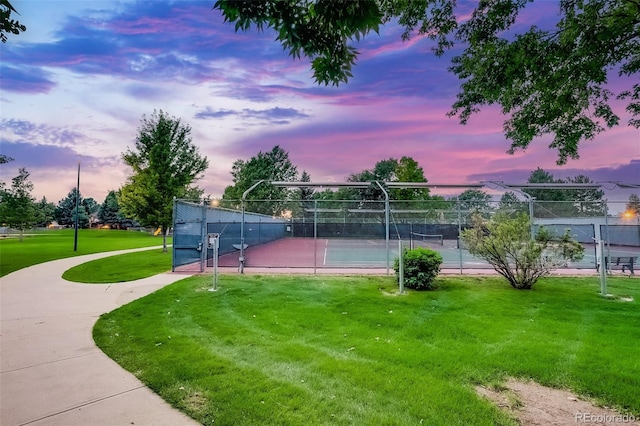 view of tennis court featuring a lawn