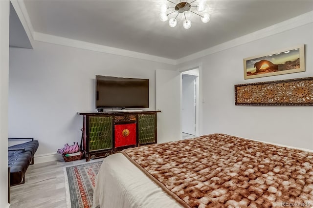 bedroom with hardwood / wood-style floors, crown molding, and a notable chandelier