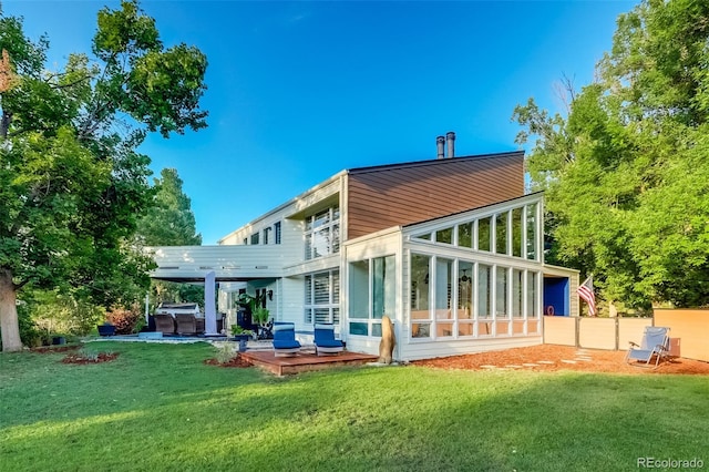 back of property with a pergola, a lawn, and a patio area