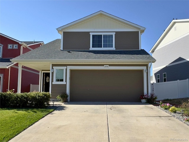 traditional-style home with driveway, roof with shingles, fence, and a garage