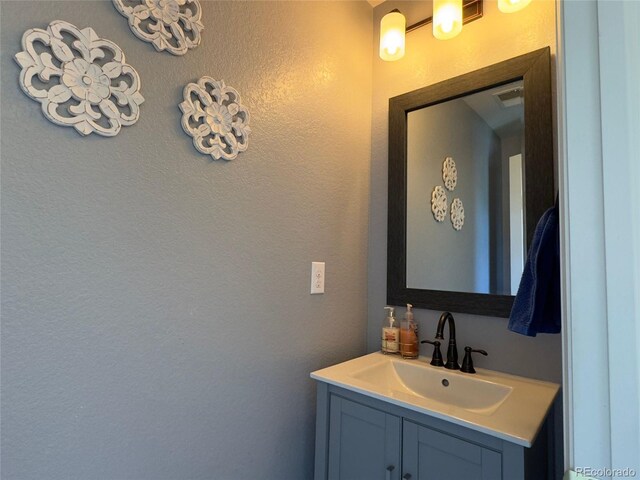 bathroom featuring vanity and a textured wall