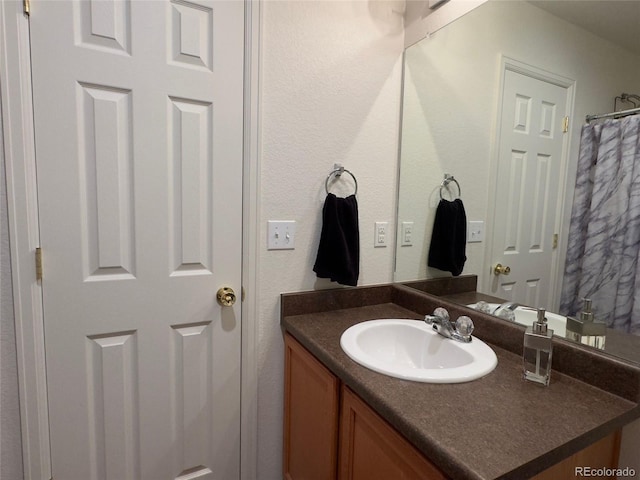 bathroom featuring vanity and a textured wall