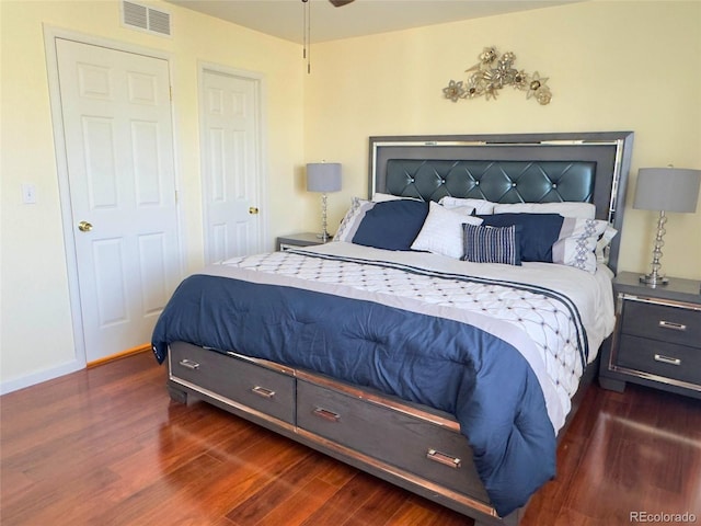 bedroom featuring baseboards, dark wood-style flooring, and visible vents