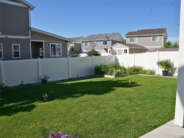 view of yard with a garden, a residential view, and a fenced backyard