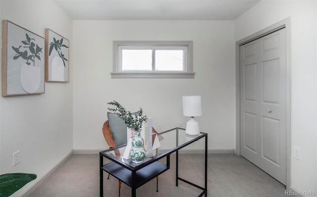 home office with baseboards and light colored carpet