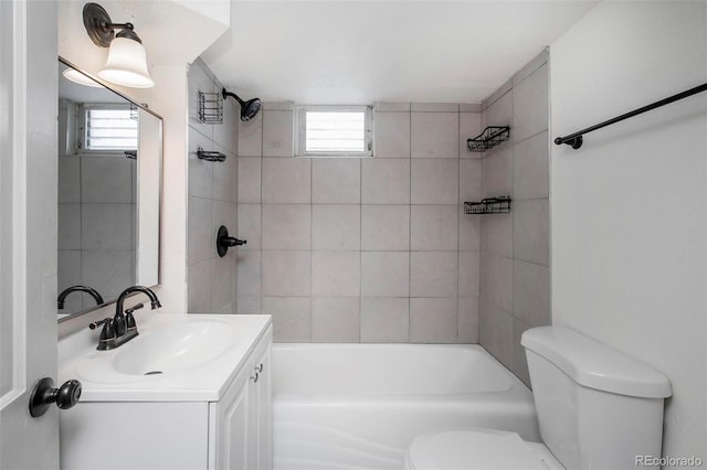 bathroom featuring toilet, tub / shower combination, a healthy amount of sunlight, and vanity