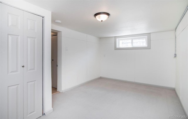 basement with baseboards and light carpet