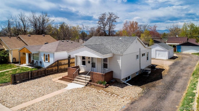 ranch-style home featuring roof with shingles, fence, a garage, central air condition unit, and an outdoor structure