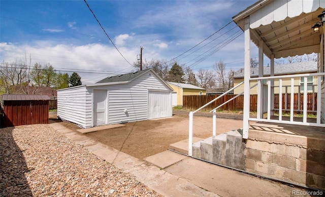 view of patio / terrace with an outdoor structure and fence