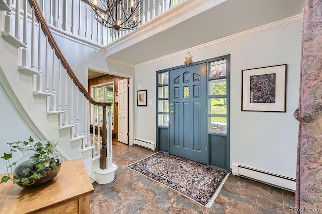 6451 Crestbrook Dr, Morrison, CO 80465 - entryway featuring baseboard heating, stairway, a chandelier, stone finish flooring, and ornamental molding