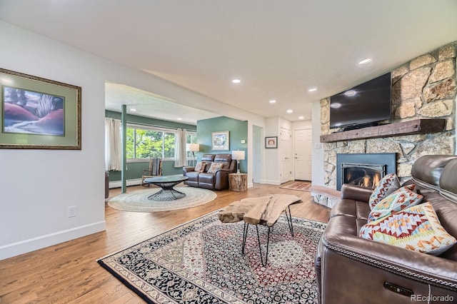 6451 Crestbrook Dr, Morrison, CO 80465 - living area featuring baseboards, wood-type flooring, baseboard heating, a stone fireplace, and recessed lighting