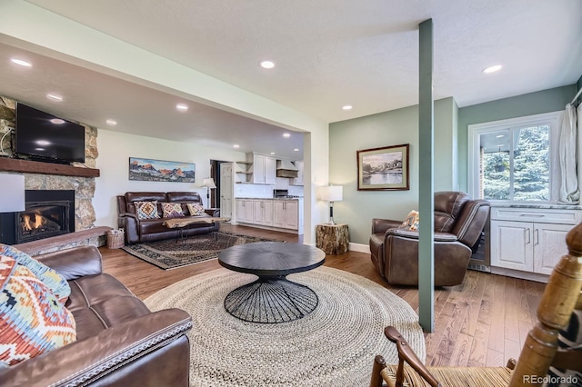 6451 Crestbrook Dr, Morrison, CO 80465 - living room with a stone fireplace, wood finished floors, recessed lighting, and baseboards