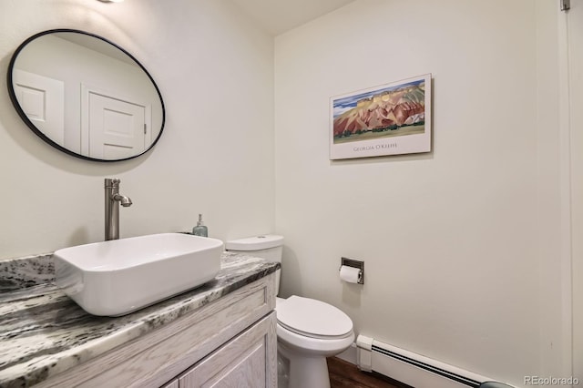 6451 Crestbrook Dr, Morrison, CO 80465 - bathroom featuring wood finished floors, vanity, baseboard heating, and toilet