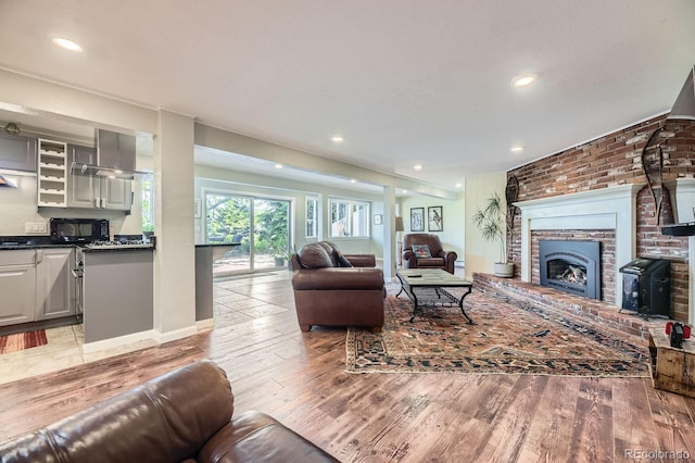 6451 Crestbrook Dr, Morrison, CO 80465 - living area featuring light wood finished floors, recessed lighting, a brick fireplace, brick wall, and baseboards