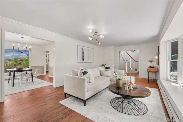 6451 Crestbrook Dr, Morrison, CO 80465 - living area featuring a chandelier, stairs, baseboard heating, crown molding, and wood finished floors