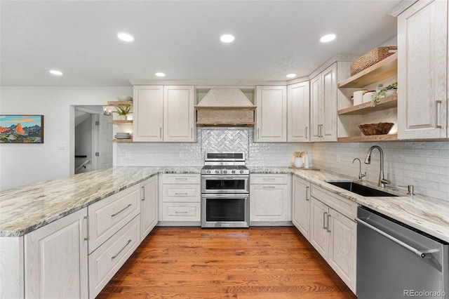 6451 Crestbrook Dr, Morrison, CO 80465 - kitchen featuring open shelves, appliances with stainless steel finishes, custom range hood, a peninsula, and light stone countertops