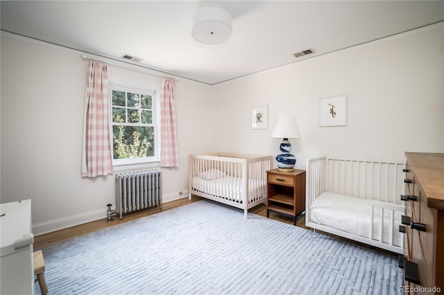 bedroom featuring wood-type flooring and radiator