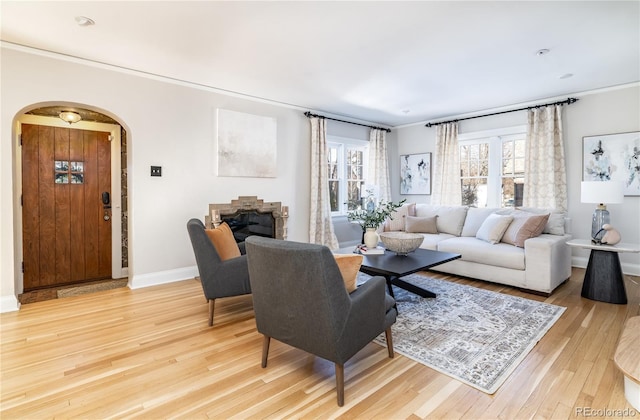 living room featuring light wood-type flooring and crown molding