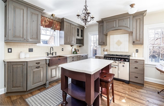 kitchen featuring gray cabinets, stainless steel gas cooktop, hardwood / wood-style flooring, and a notable chandelier