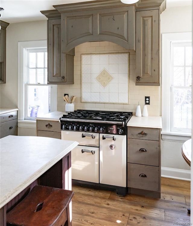 kitchen with a wealth of natural light, decorative backsplash, and dark hardwood / wood-style floors