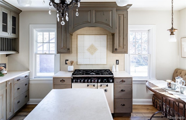 kitchen with pendant lighting, backsplash, dark hardwood / wood-style flooring, and plenty of natural light