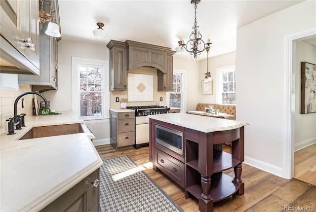 kitchen featuring backsplash, sink, hanging light fixtures, dark hardwood / wood-style floors, and stainless steel appliances