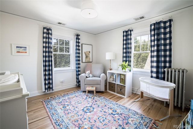 living area with radiator and light hardwood / wood-style floors