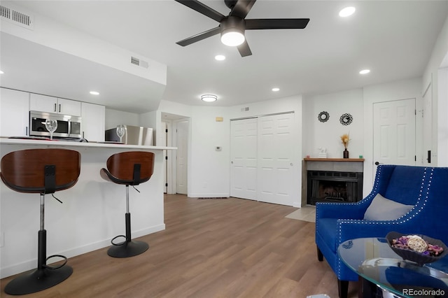 8701 Huron St Unit 2-106, Thornton, CO 80260 - living area featuring a fireplace with flush hearth, a ceiling fan, wood finished floors, and recessed lighting