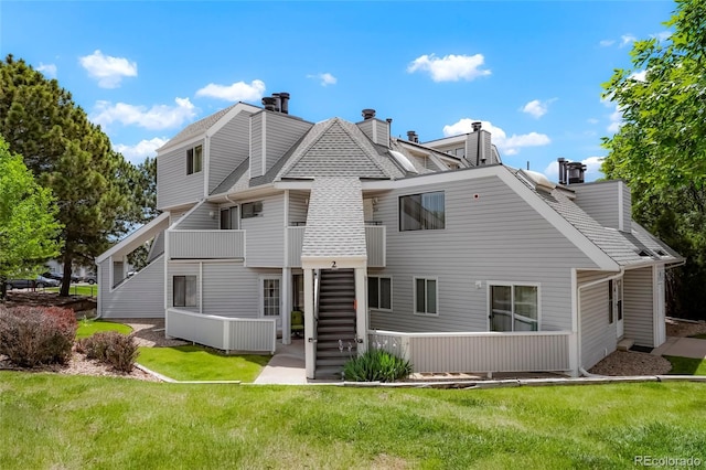 8701 Huron St Unit 2-106, Thornton, CO 80260 - rear view of house with a chimney, a yard, roof with shingles, and a balcony