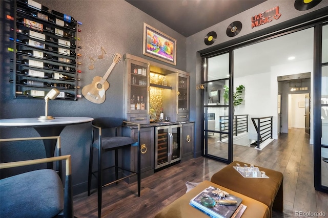 1004 Tree Bark Ter, Colorado Springs, CO 80921 - indoor bar with beverage cooler, a textured wall, and dark wood finished floors