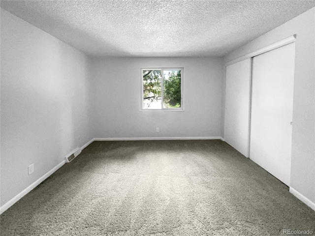 unfurnished bedroom featuring carpet floors, a closet, and a textured ceiling