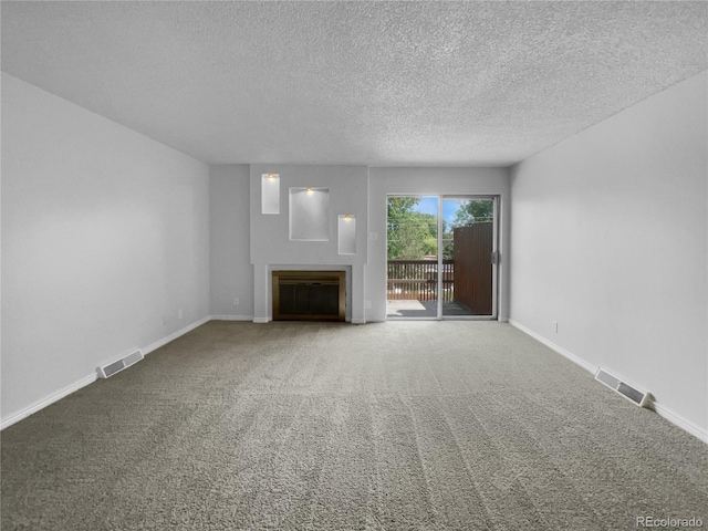 unfurnished living room with a textured ceiling and carpet