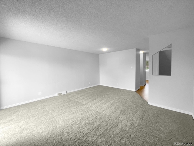 carpeted spare room featuring a textured ceiling