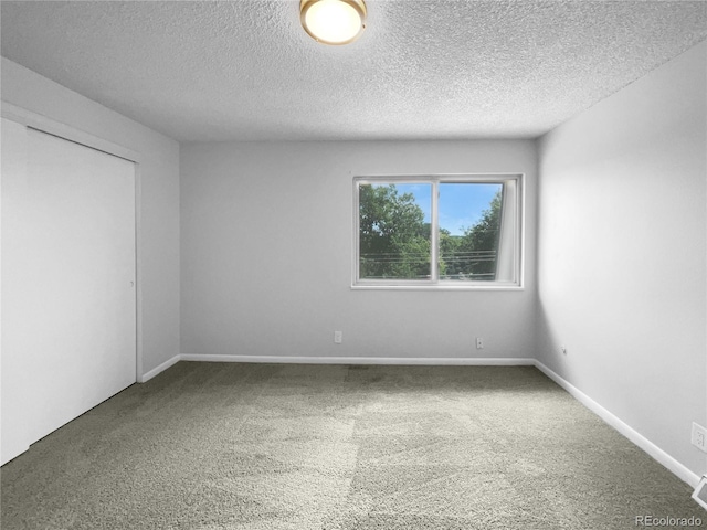 carpeted spare room featuring a textured ceiling