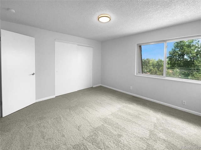 spare room featuring a textured ceiling and carpet