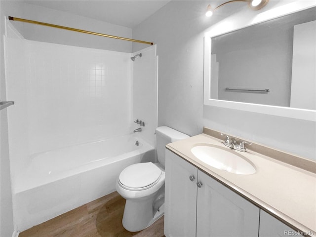 full bathroom featuring shower / bathing tub combination, hardwood / wood-style floors, vanity, and toilet