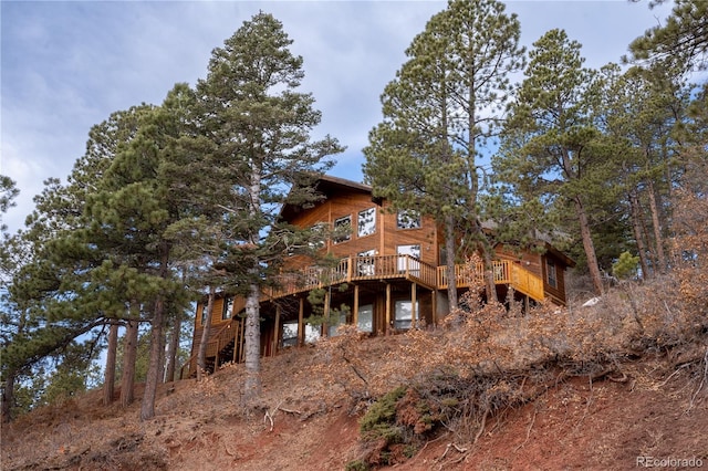 rear view of property featuring a wooden deck