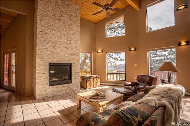 tiled living room with a fireplace, wooden ceiling, ceiling fan, and vaulted ceiling