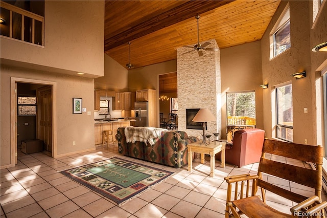 tiled living room featuring wood ceiling, ceiling fan, high vaulted ceiling, and sink